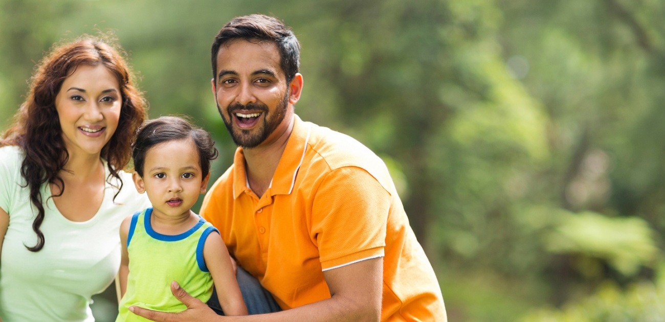 Family of three smiling after receiving dental services