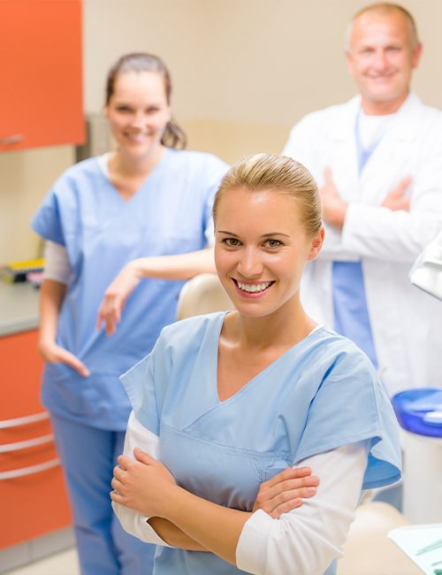 Three smiling dental team members