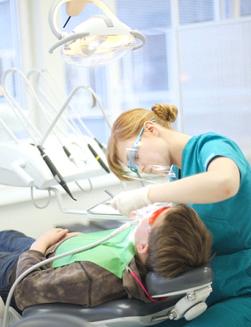 Children's dentist providing teeth cleaning