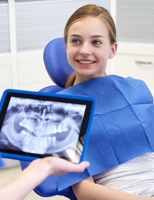 Young girl smiling at dentist during dental checkup and teeth cleaning visit