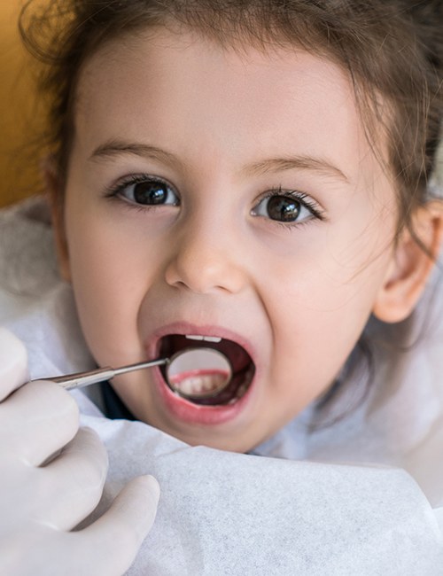 Dentist checking child's tooth colored fillings