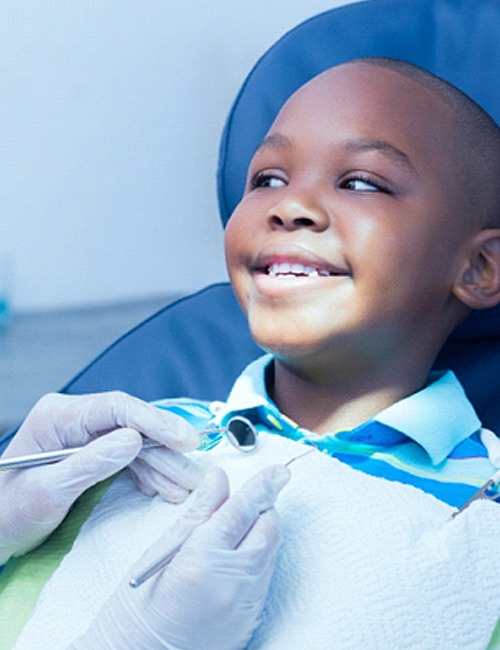 A young boy smiling after receiving a positive report from his dentist