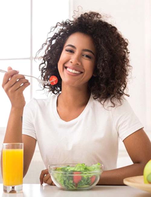 smiling woman eating a salad