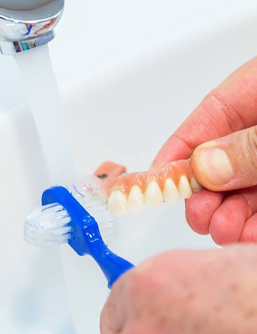 Patient brushing denture restoration