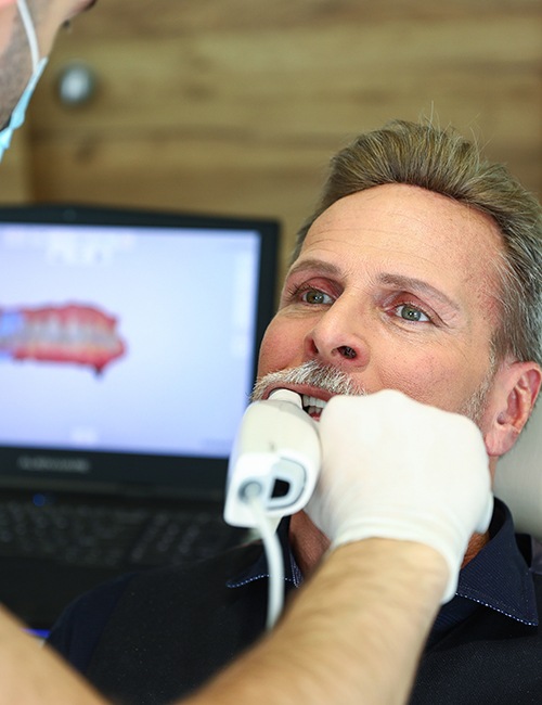 Dentist examining patient's dental implant retained denture