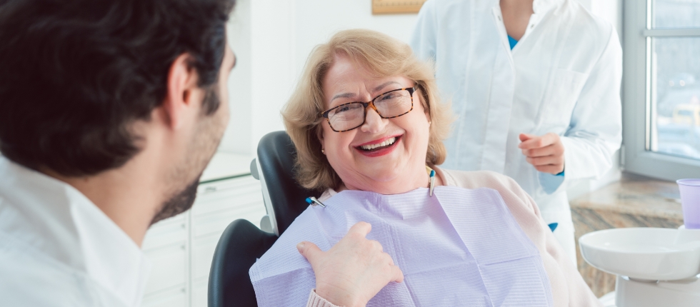 Woman in dental chair smiling at dentist