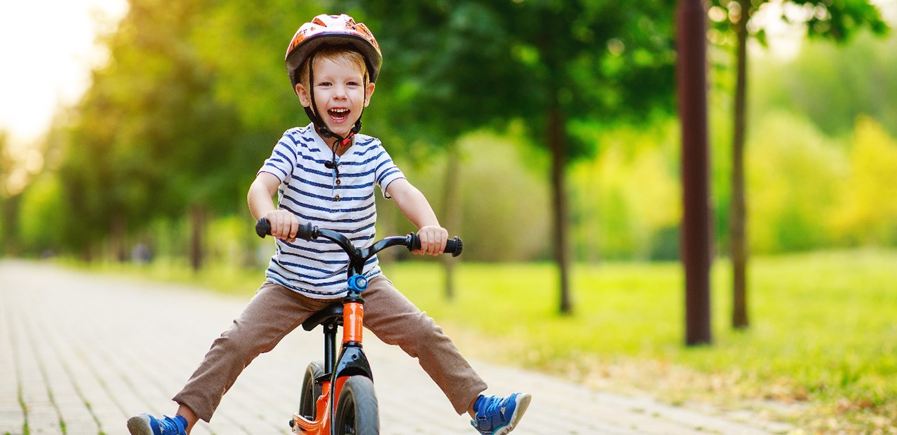 young boy smiling while riding bike