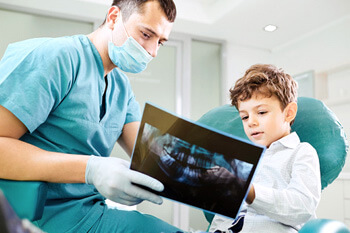 dentist reviewing xray with child in treatment room
