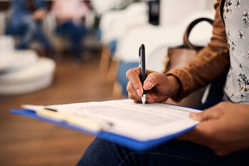 woman filling out dental insurance form in lobby