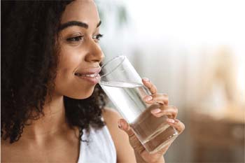 woman drinking water and having a healthy diet for dental implants in Copperas Cove