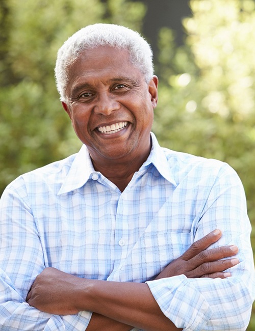 Senior man with implant dentures in Copperas Cove, TX outside and smiling