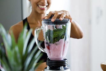 woman making smoothie after getting dental implants in Copperas Cove