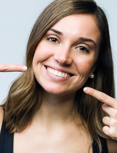 woman pointing to her smile