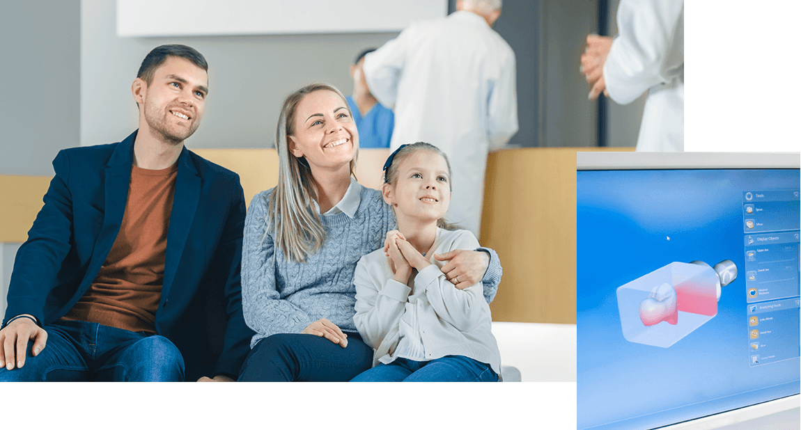 Family of three smiling at dentist and digital smile design image on computer screen