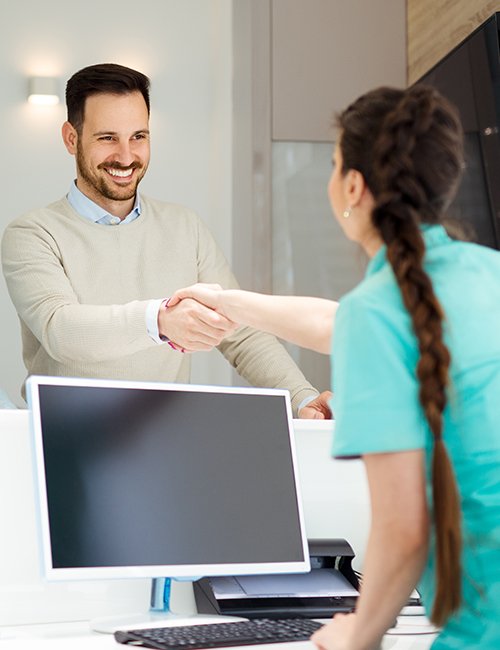 Man checking in at dental office reception desk