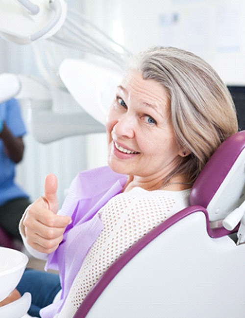 Woman giving thumbs-up while visiting the dentist
