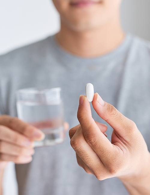 Patient holding an oral conscious dental sedation pill