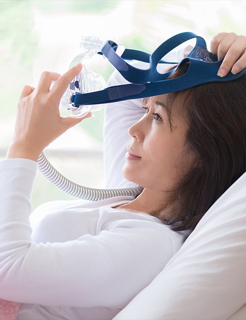 Woman placing CPAP appliance for sleep apnea