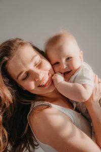 Mother hugging smiling infant