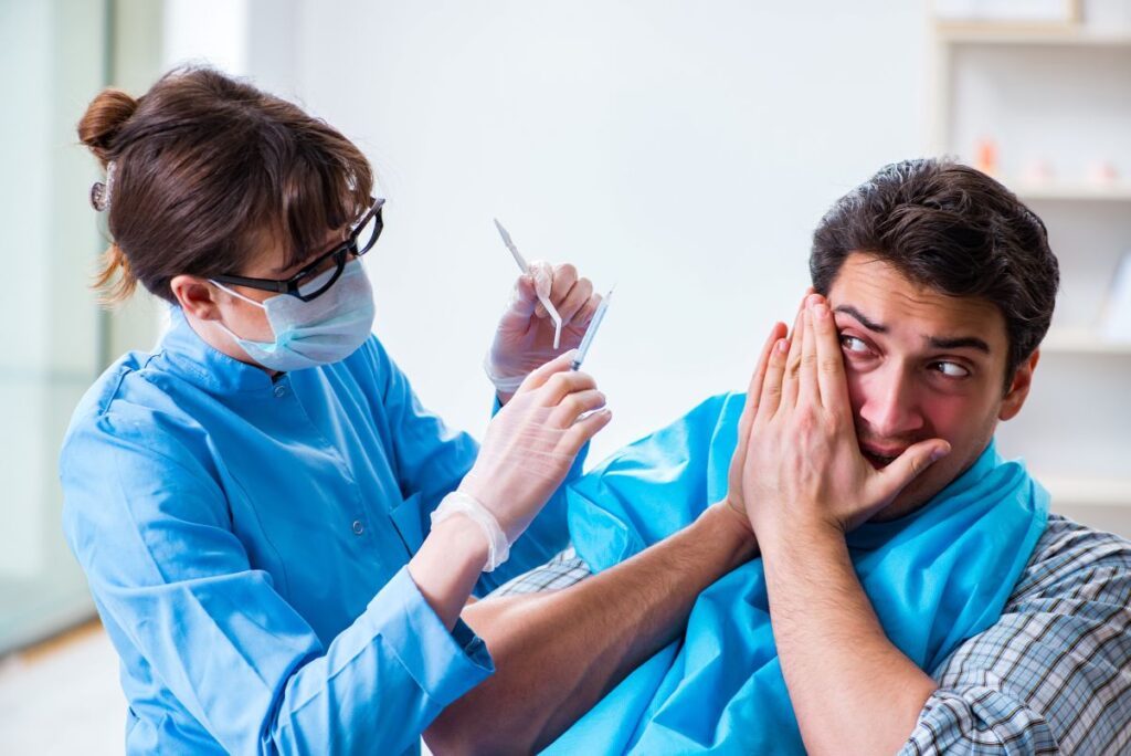 A man covering his mouth to avoid a dentist