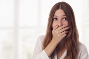 Woman hiding smile behind hand.