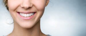 Woman smiling to reveal pretty, white teeth.